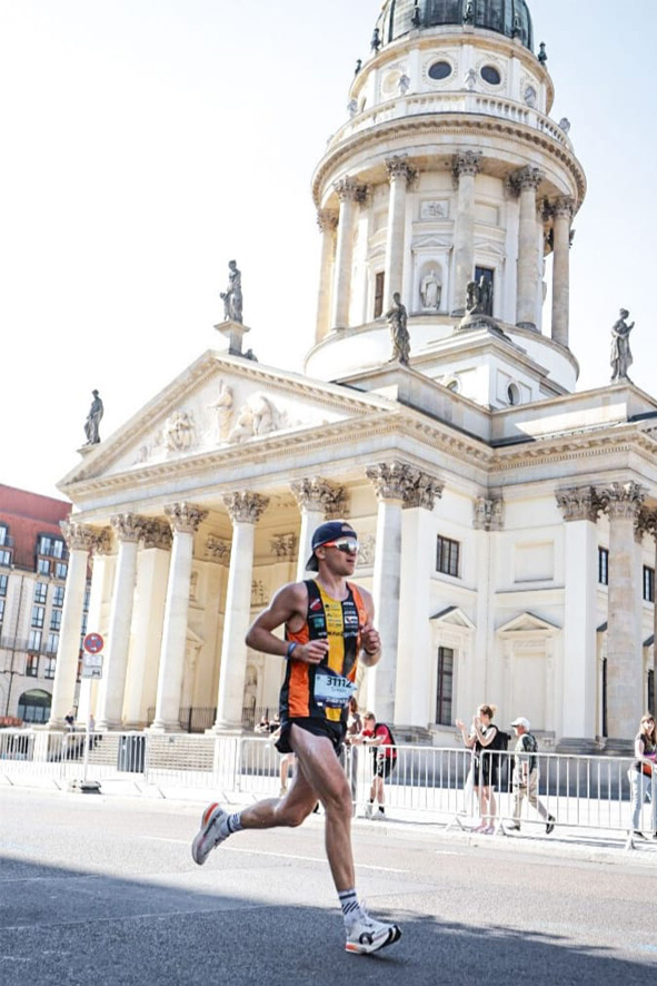 Simon Zimmer in vollem Lauf vor imposanter Kulisse in Berlin